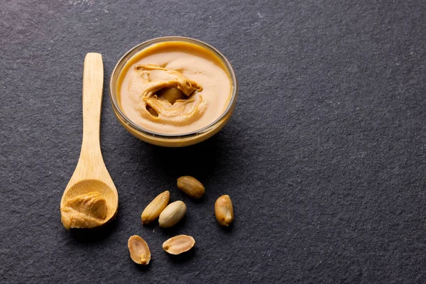 Imagem Colher Tigela Com Manteiga Amendoim Nozes Superfície Cinzenta Escura — Fotografia de Stock