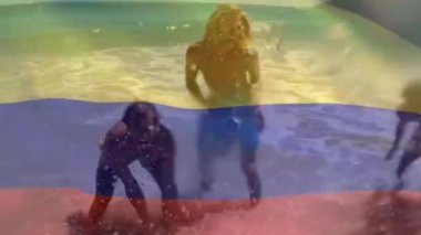 Kolombiya bayrağının mutlu Kafkas arkadaşlarının denizde eğlenirken su sıçratması. Dijital kompozit, çoklu pozlama, birlikte, tatil, özgürlük, vatanseverlik ve kimlik kavramı.