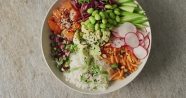 Beyaz arka planda bir kase pirinç, somon ve sebze kompozisyonu. Yiyecek, içecek ve renk konsepti.