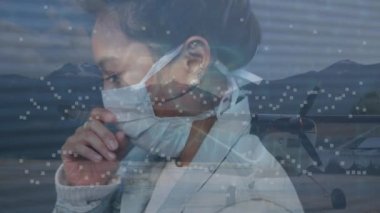 Yüz maskeli Asyalı kadının veri işleme animasyonu. Küresel iş, salgın ve dijital arayüz kavramı dijital olarak oluşturulmuş video.