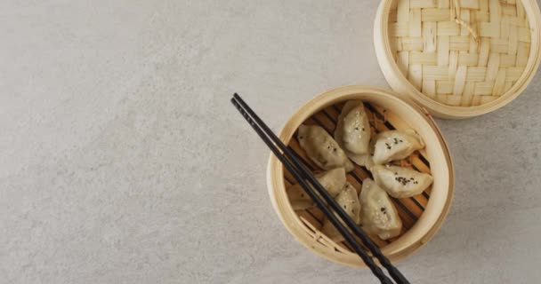 Composición Vapor Bambú Con Dumplings Gyoza Palillos Sobre Fondo Gris — Vídeo de stock