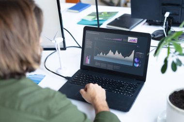 Masasında oturan beyaz iş kadını, ekranında istatistiksel veriler olan bir dizüstü bilgisayar kullanıyor. iş iletişimi ve dijital arayüz teknolojisi dijital kompozit görüntü.