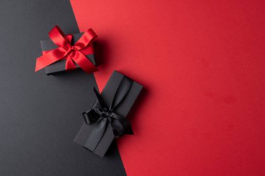 Gri ve pembe arka planda pembe ve siyah kurdeleli hediyelerin kompozisyonu. Perakende, alışveriş ve Kara Cuma konsepti.