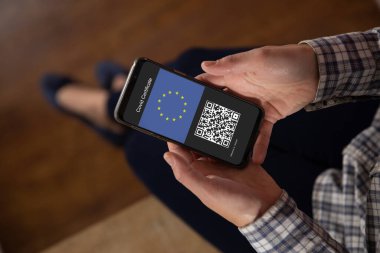 Elinde kovanlı 19 aşılı pasaportlu akıllı telefon tutan bir kadın. küresel covid 19 salgın konsepti dijital olarak oluşturulmuş video.