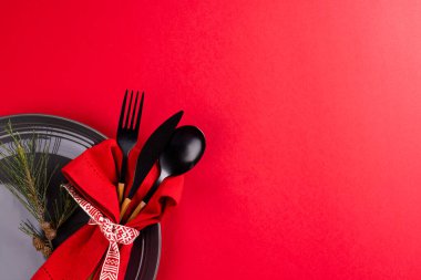 Kırmızı arkaplanda çatal bıçak takımı ve fotokopi alanı olan bir noel yeri seti. Noel, gelenek ve kutlama konsepti.