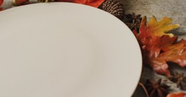 Gri yüzeyinde sonbahar yaprakları ve süslemeleri olan plaka videosu. Şükran Günü, Amerikan kültürü, gelenek ve kutlama videosu.