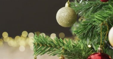 İçinde mücevherler ve siyah arka planda peri ışıkları olan bir Noel ağacı videosu. Noel, gelenek ve kutlama konsepti.