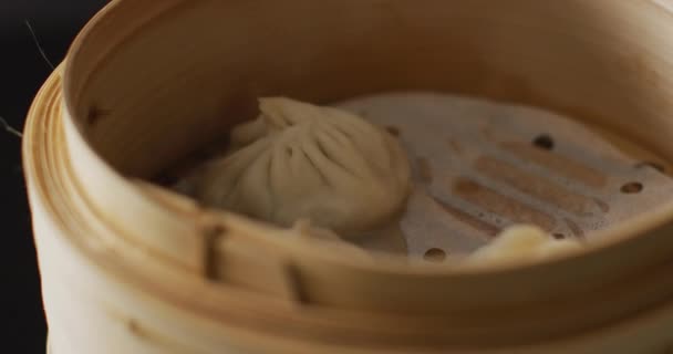 Essstäbchen Mit Dim Sum Knödel Bambusdampfer Auf Schwarzem Hintergrund Essen — Stockvideo