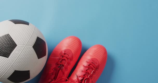 蓝色背景上的足球和红鞋动画 有复制空间 培训和积极生活方式概念 — 图库视频影像