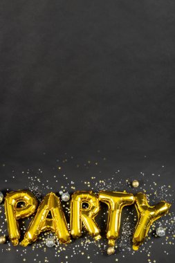 Siyah arkaplanda konfeti olan parti metninin yakın plan kompozisyonu. Yeni yıl partisi, kutlama ve uzay konseptini kopyalama.