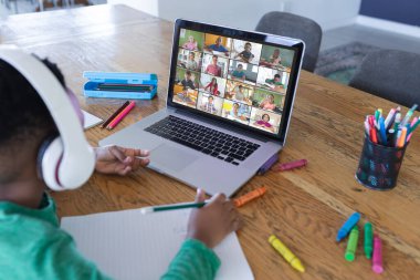 Ekranda ilkokul öğrencileriyle video görüşmesi için dizüstü bilgisayar kullanan Afrikalı Amerikalı bir çocuk. iletişim teknolojisi ve çevrimiçi eğitim, dijital kompozit resim.