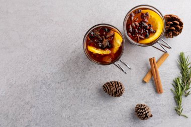Baharatlı ve limonlu iki fincan çay resmi ve gri üzerinde fotokopi alanı olan noel süslemeleri. Noel, gelenek ve kutlama konsepti.