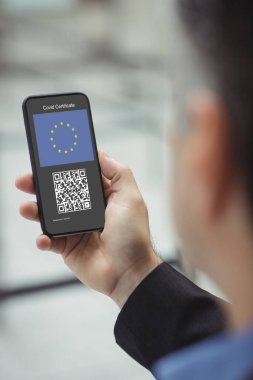 Elinde kovanlı 19 aşılı pasaportlu akıllı telefon tutan adam. küresel covid 19 salgın konsepti dijital olarak oluşturulmuş video.