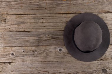 Ahşap yüzeyde duran yün şapka resmi. Giysiler, tekstil, moda, tarz ve kıyafet konsepti.