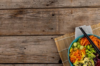 Havai Poke Bowl 'un yemek çubukları ve minder ve ahşap arka planda fotokopi alanı manzarası. Hawaii Lezzetli Taze Yemek ve Sağlıklı Yeme.