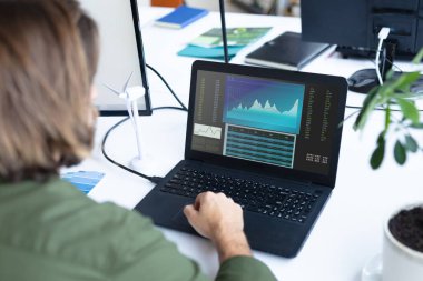 Masada oturan beyaz iş kadını ekranda istatistiksel verileri olan bir dizüstü bilgisayar kullanıyor. iş iletişimi ve dijital arayüz teknolojisi dijital kompozit görüntü.