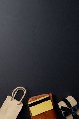 Çanta, cüzdan, hediye ve kredi kartı kompozisyonu ve gri arka planda fotokopi alanı. Perakende, alışveriş ve Kara Cuma konsepti.