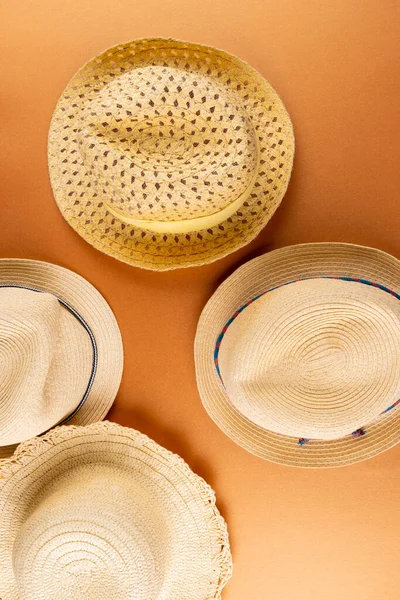 Vertical image of straw hats on yellow surface. Clothes, textiles, fashion, style and outfit concept.