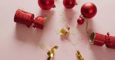 Noel balolarının, dekorasyonların ve pembe arka planda noel hediyelerinin videosu. Noel, gelenek ve kutlama konsepti.