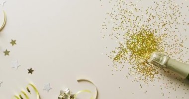 İçinde altın flamalar, yıldızlar, parıltı ve mücevherler olan şampanya şişesinin videosu. Yeni yıl partisi ve kutlama konsepti.