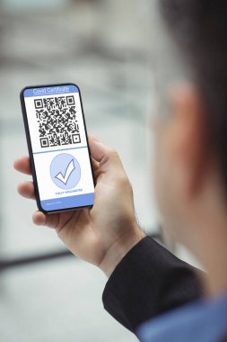 Elinde kovanlı 19 aşılı pasaportlu akıllı telefon tutan adam. küresel covid 19 salgın konsepti dijital olarak oluşturulmuş video.