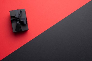 Gri ve pembe arka planda siyah kurdeleli mevcut kompozisyon. Perakende, alışveriş ve Kara Cuma konsepti.