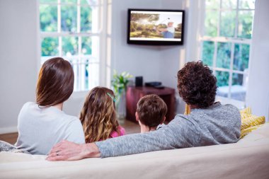 Evde kanepede otururken televizyon izlerken aile