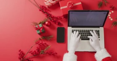 Noel Baba, Noel süslemeleri için dizüstü bilgisayarı kullanıyor. Noel, gelenek ve kutlama ve teknoloji konsepti.