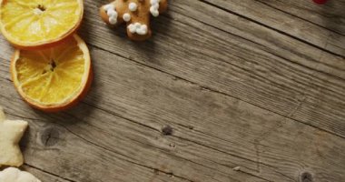 Tahta arka planda bisküvi, portakal ve kırmızı meyvelerin videosu. Noel, gelenek ve kutlama konsepti.