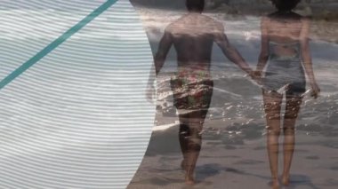 Afrika kökenli Amerikalı çiftin deniz kenarındaki yeşil çemberin üzerindeki animasyonları. Seyahat, tatil ve boş zaman konsepti dijital olarak oluşturulmuş video.