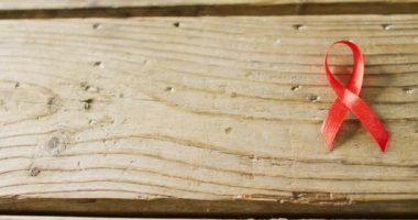 Ahşap arka planda kırmızı kanser kurdelesinin yakın çekim videosu. Kalp Günü, kutlama ve uzay konseptini kopyalama.