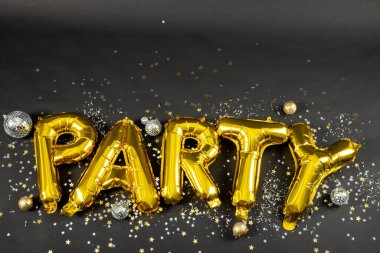 Siyah arkaplanda konfeti olan parti metninin yakın plan kompozisyonu. Yeni yıl partisi, kutlama ve uzay konseptini kopyalama.