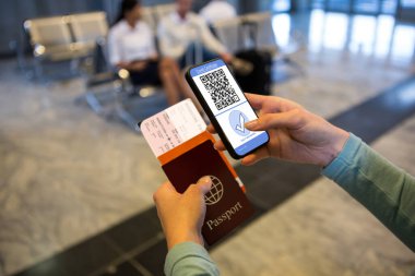Havaalanında elinde belgeler ve elinde 19 aşılı pasaportlu akıllı telefon olan bir kadın var. küresel covid 19 salgın konsepti dijital olarak oluşturulmuş video.