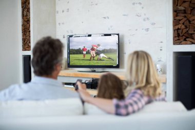 Evde oturup televizyonda spor müsabakalarını izleyen aile manzarası. spor, rekabet, eğlence ve teknoloji konsepti dijital kompozit görüntü.