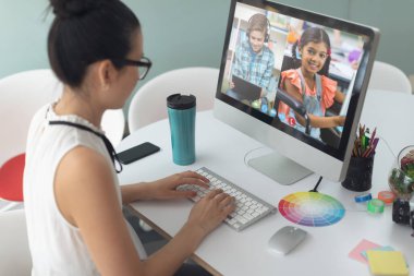 Asyalı kız ekranda çeşitli ilköğretim öğrencileri gülümserken görüntülü konuşma için bilgisayar kullanıyor. iletişim teknolojisi ve çevrimiçi eğitim, dijital kompozit resim.