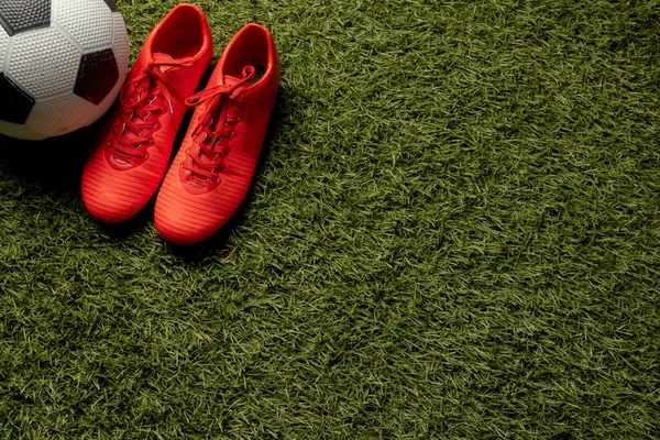 Spor stadyumunun ve fotokopi alanının üzerinde futbol ve ayakkabı kompozisyonu. Spor, hareket, eğitim ve aktif yaşam tarzı kavramı.