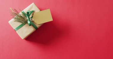 Kırmızı arka planda noel hediyesi ve fotokopi alanı videosu. Noel, gelenek ve kutlama konsepti.