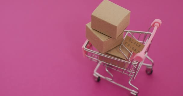 Kartondaki Kara Cuma Metinlerinin Videosu Pembe Arka Plandaki Alışveriş Arabasındaki — Stok video