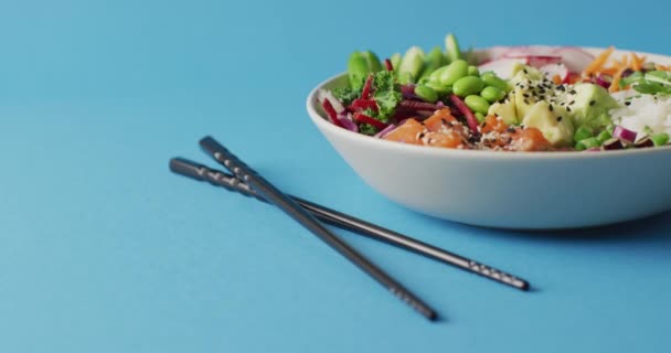 Composición Del Tazón Arroz Verduras Con Palillos Sobre Fondo Azul — Vídeos de Stock