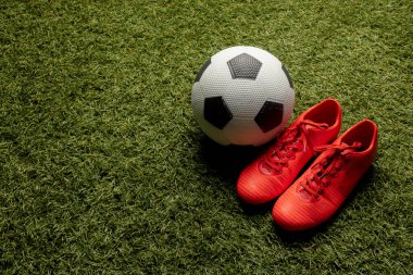 Spor stadyumunun ve fotokopi alanının üzerinde futbol ve ayakkabı kompozisyonu. Spor, hareket, eğitim ve aktif yaşam tarzı kavramı.