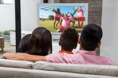 Mutlu aile kanepede televizyon izlerken arka görünümü
