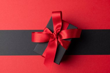 Gri ve pembe arkaplanlı pembe kurdeleli mevcut kompozisyon. Perakende, alışveriş ve Kara Cuma konsepti.