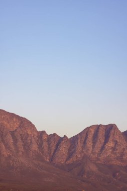 Bulutsuz mavi gökyüzüne karşı taş ve çakıl taşlarıyla kayalık dağların manzarası. Manzara, dağlar ve doğa konsepti.