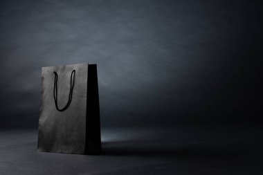 Gri arka planda gri kağıt alışveriş torbası kompozisyonu. Perakende, alışveriş ve Kara Cuma konsepti.