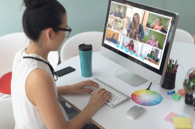 Asyalı bir kadın ekranda çeşitli ilkokul öğrencileriyle video görüşmesi için bilgisayar kullanıyor. iletişim teknolojisi ve çevrimiçi eğitim, dijital kompozit resim.