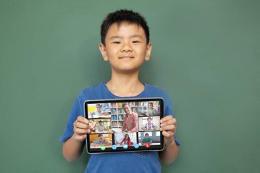 Çeşitli ilkokul öğrencileriyle video görüşmesi için elinde tablet olan gülümseyen Asyalı çocuk. iletişim teknolojisi ve çevrimiçi eğitim, dijital kompozit resim.