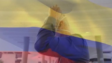 Şehir caddesinde yüz maskesi takmış beyaz bir adamın üzerinde sallanan kamerun bayrağı animasyonu. covid 19 salgın konsepti boyunca dijital olarak üretilen küresel sağlık önlemleri.