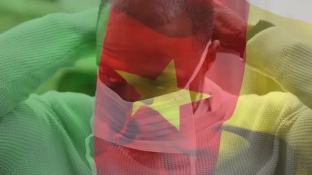 Animación Bandera Camerún Ondeando Sobre Hombre Afroamericano Con Máscara Facial — Vídeo de stock