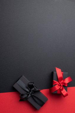 Gri ve pembe arka planda pembe ve siyah kurdeleli hediyelerin kompozisyonu. Perakende, alışveriş ve Kara Cuma konsepti.