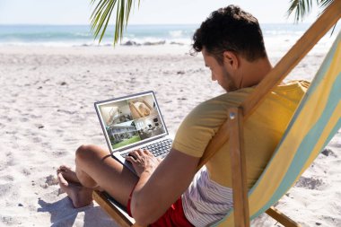 Tatilde olan beyaz bir adam, ekrandaki güvenlik kameralarından ev manzaralı dizüstü bilgisayar kullanıyor. güvenlik, güvenlik, izleme ve dijital arayüz.